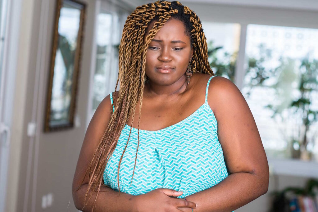 fibroid symptom constipation pain woman with hand on stomach